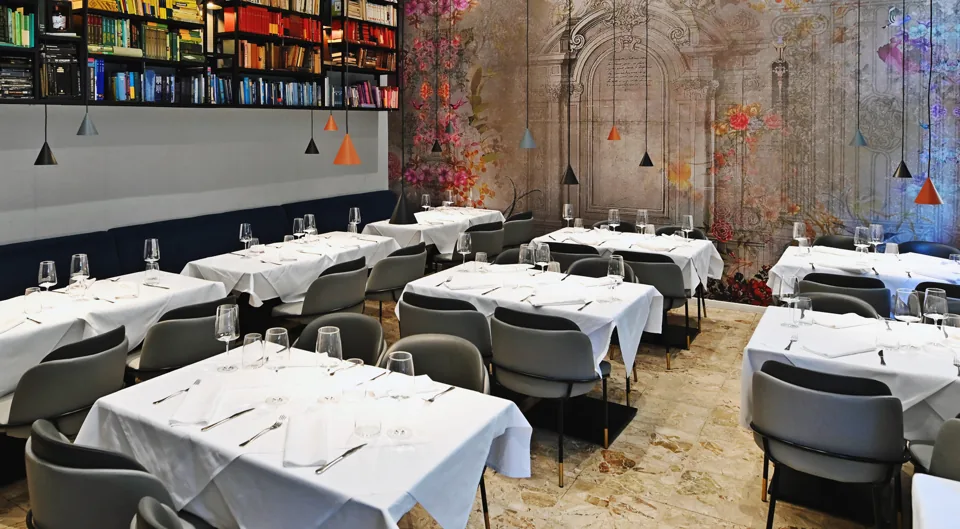 Stolovi s bijelim stolnjacima u blagovaonici Bistroa Lata